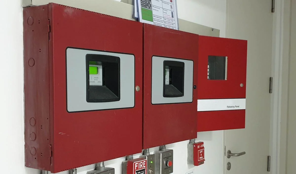Multiple fire alarm control panels and releasing panel installed on commercial building wall
